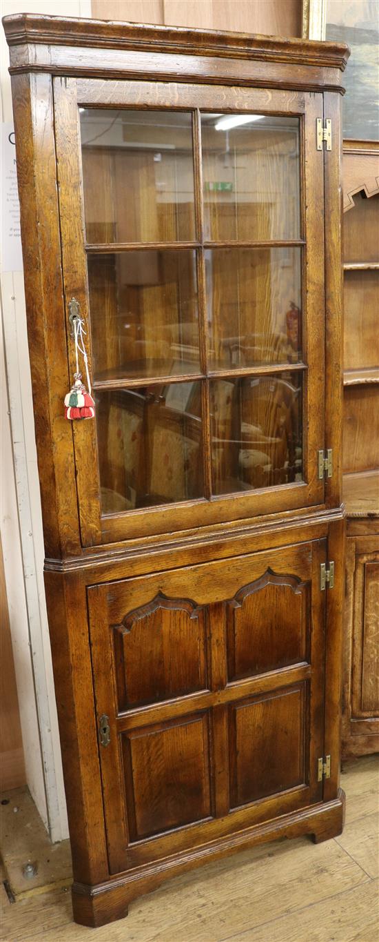 A reproduction oak corner cabinet, H.183cm